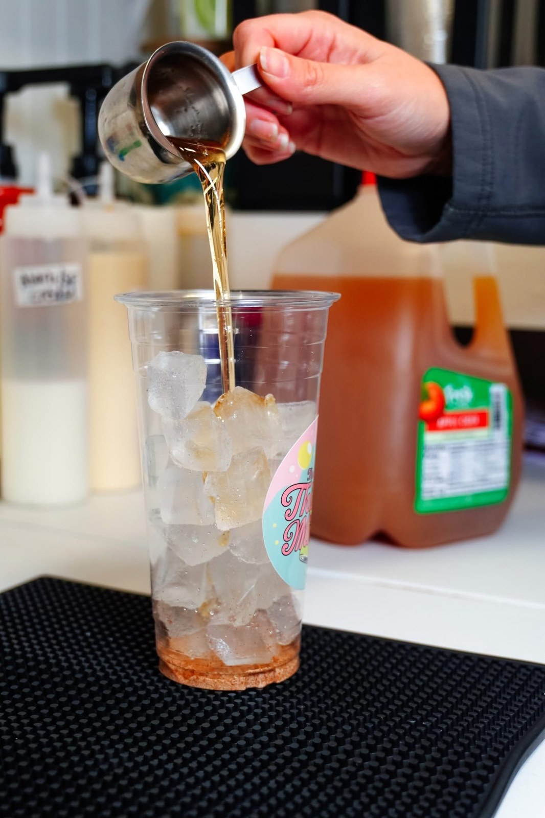 Soda being poured into a branded Thirsty Mitten cup